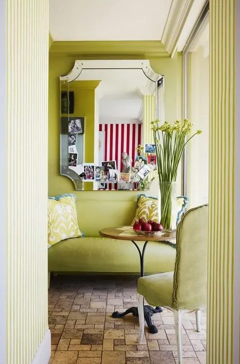 A refined chartreuse space with a matching loveseat and chair, a coffee table, a mirror and printed pillows is jaw dropping