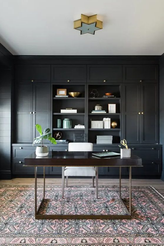 a soot farmhouse home office with built in cabinetry, a dark stained vanity and a white chair, a star shaped lamp