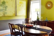 a sophisticated chartreuse dining room with paneling, a vintage dinign furniture set, a console table and some artwork
