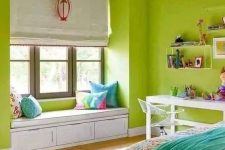 a super bright chartreuse bedroom with a bed and printed bedding, a desk and shelves, a windowsill bench with pillows