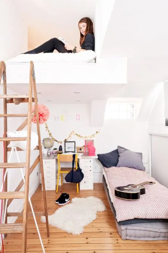 a two level girl's bedroom with a loft bedroom and a bed and a desk on the lower level plus a staircase
