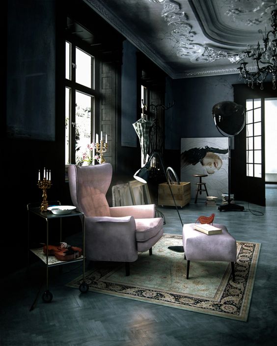a unique Gothic space with soot walls, an ornated ceiling, a pink chair with a footrest, some wooden furniture, artwork and a rug
