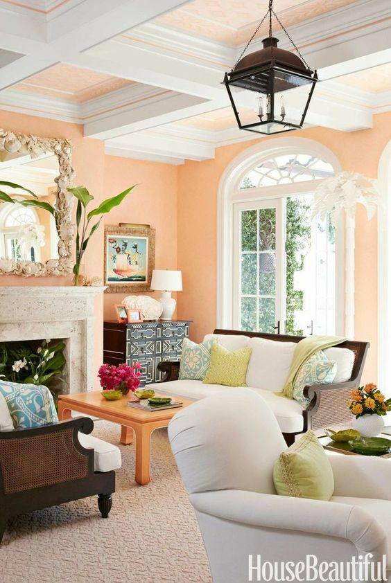 an eclectic living room with PEach Fuzz walls and a ceiling, a fireplace, neutral seating furniture and beautiful decor and plants