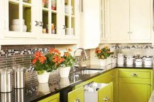 an eye-catchy creamy and chartreuse kitchen with a skinny tile backsplash and a black countertop is a cool and creative idea