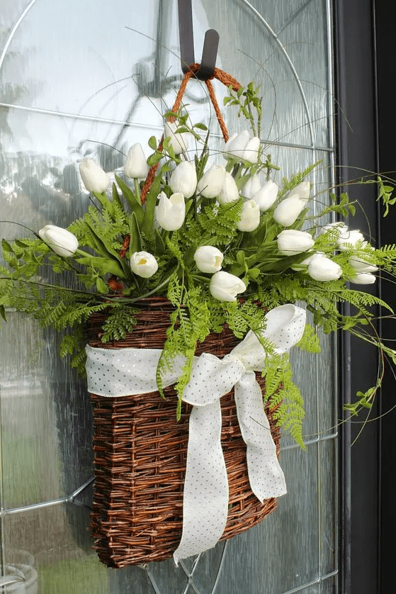 a basket with ferns, white tulips, a polka dot ribbon bow is a lovely alternative to a usual spring wreath