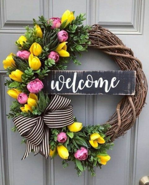 a bright rustic spring wreath of vine, with pink peonies and yellow tulips, a striped bow and a sign is amazing