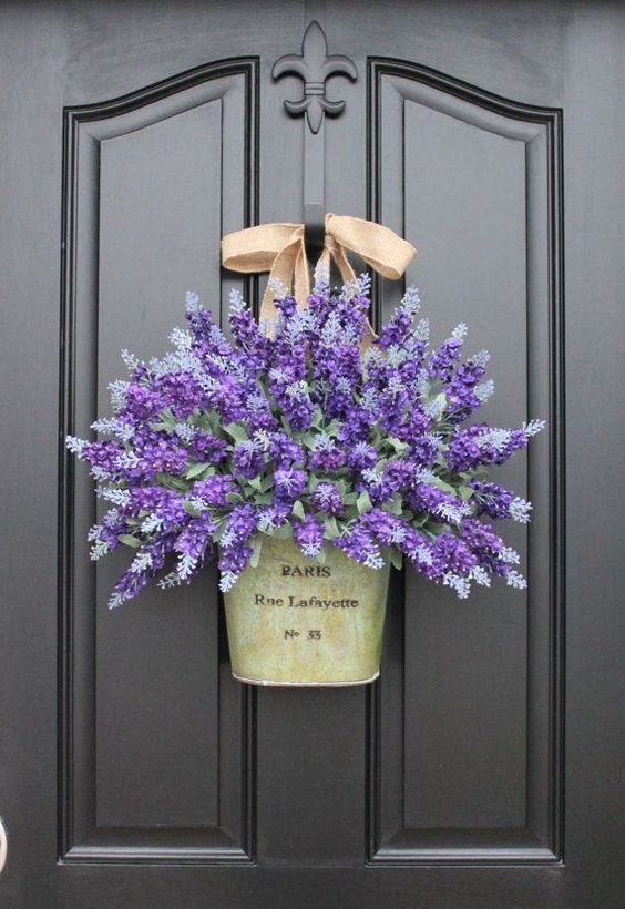 a bright spring door decoration of a bucket with purple and lilac blooms is a gorgeous alternative to a wreath