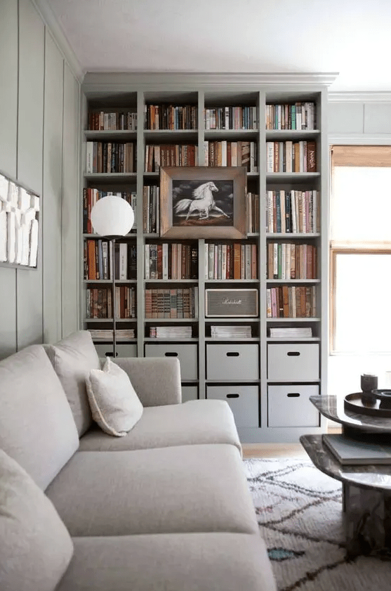 a built-in bookshelf unit with box drawers and a large artwork on it is perfect for a contemporary space