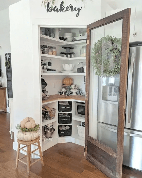 a cool and cozy smal pantry with built in shelves and storage compartments, appliances, cookware and some decor