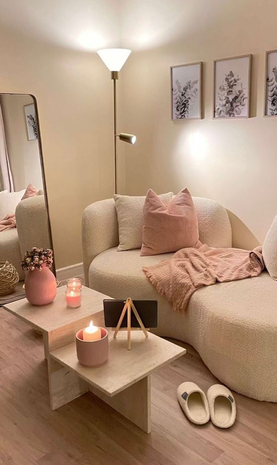 a cozy nook with a white boucle loveseat, a mirror, a floor lamp, a coffee table, some pink touches to make it cuter