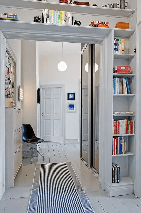 a doorway with open shelves covering the whole space over it is a cool idea to store some things and use the unused space