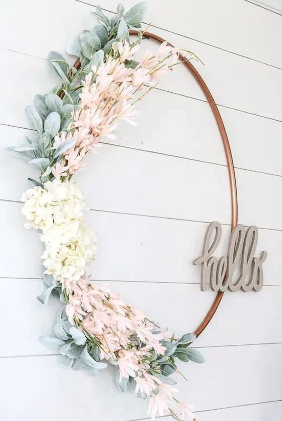 a fresh and pretty spring wreath of a large hoop, faux greenery, white and pink blooms and with a HELLO piece