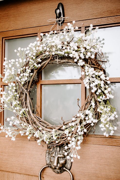 a lovely spring wreath of vine and white blooms is a classic solution for the season