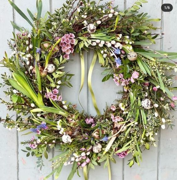 a lush and textured spring wreath with greenery, spring bulbs and smaller blooms and speckled eggs is wow