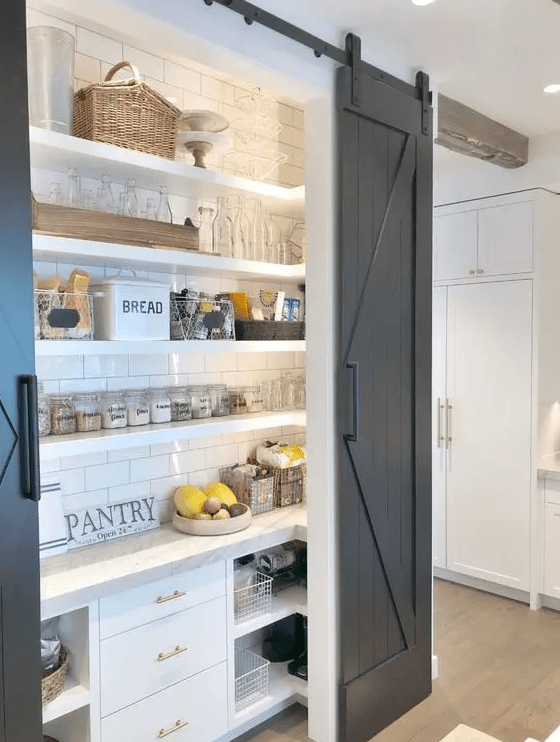 a small and cozy rustic pantry with open shelves and built in storage cabinets, built in lights, baskets, jars and wire baskets
