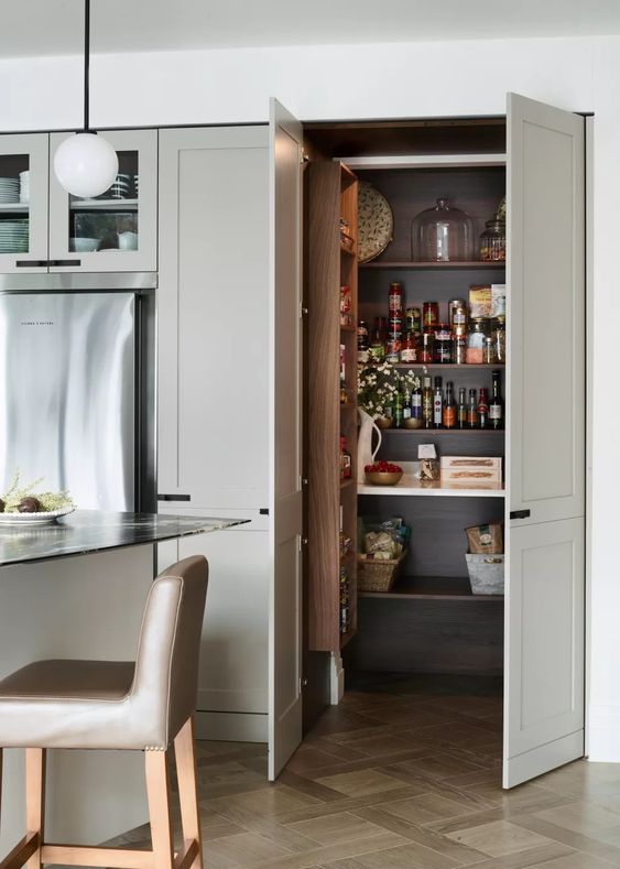 a small pantry that is cohesive in the kitchen, with doors, open shelves and a shelving unit for spices plus some lights