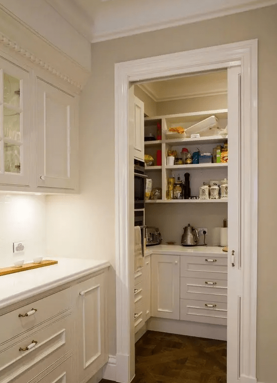 a small pantry with open shelves and built in storage cabnets, appliances, food and cookware to keep the kitchen clean and decluttered