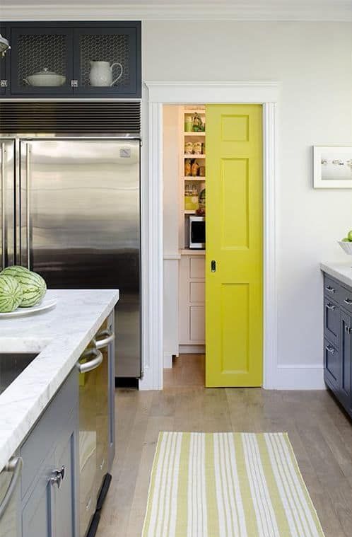 a small walk-in pantry with a neon yellow sliding door, with cabinetry, shelves and lights is a cool idea