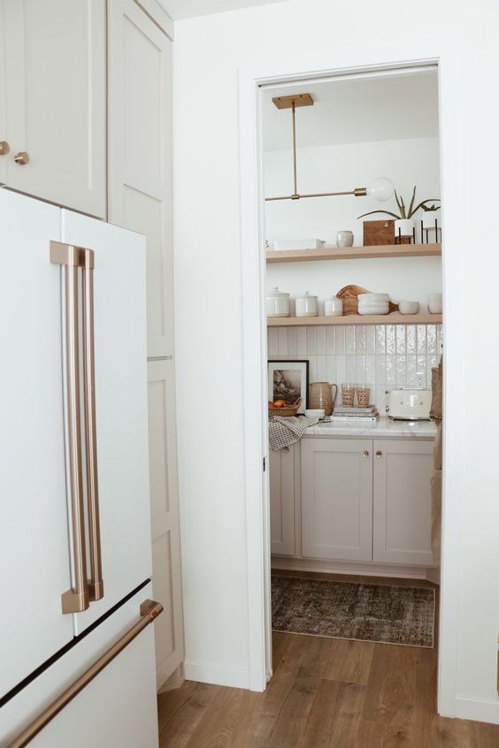 a small walk in pantry with cabinetry, open shelves, a tile backsplash and even various decor