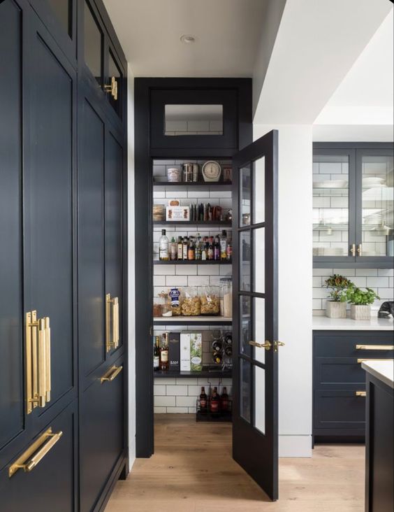 a soot farmhouse kitchen with a small pantry with open shelves and subway tiles on the walls for easy cleaning
