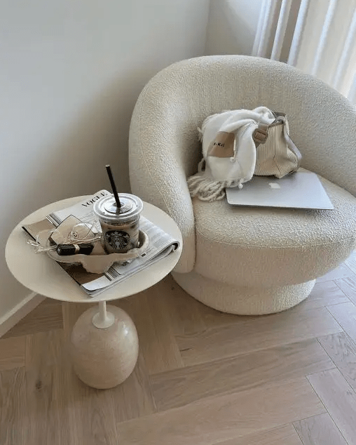 a stylish and aesthetic nook with a white boucle chair and a side table on a quirky base is a great space for anything