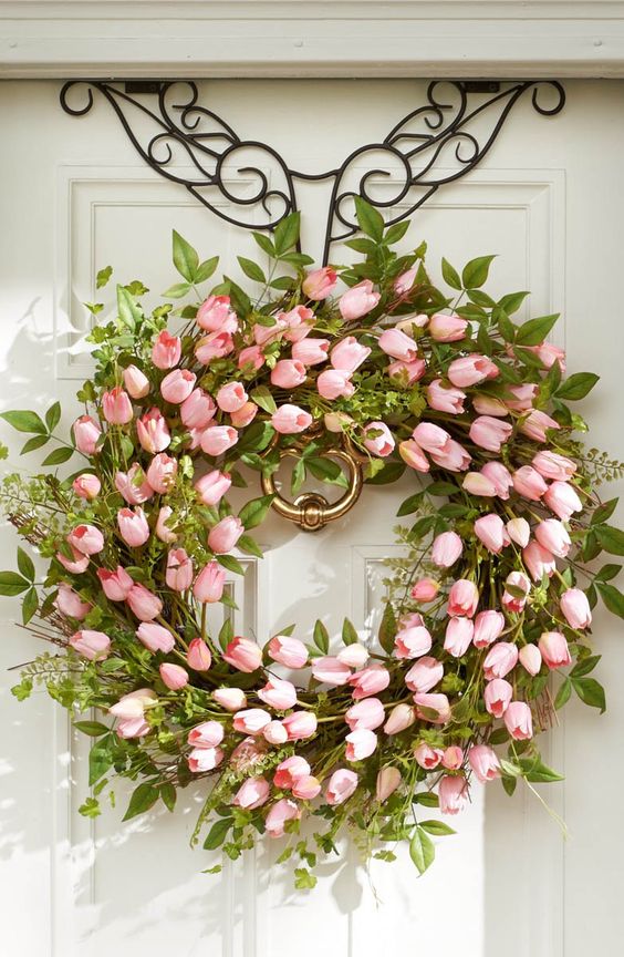 a super lush psring wreath of greenery, leaves and pink tulips is a timeless idea to decorate the front door