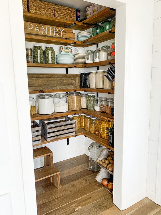 a walk-in farmhouse pantry with stained shelves, a ladder, some baskets and lot sof jars is a lovely space