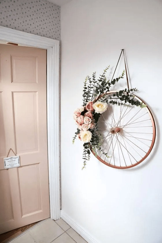 an old bike wheel wreath with pink and white blooms plus eucalyptus is a beautiful and rustic idea for spring