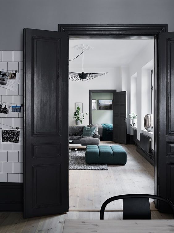 a Scandinavian home in black and white, with black doors that add contrast and interest to each space
