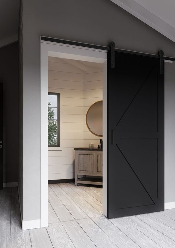 a black barn door is a perfect solution for a farmhouse space, it will bring inteerst to the neutral space and make it stand out