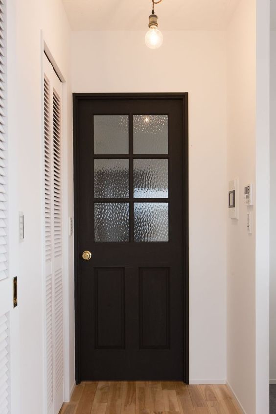 a black door will look more lightweight and not that dramatic if you add glass to it, like rainglass here, and gold hardware