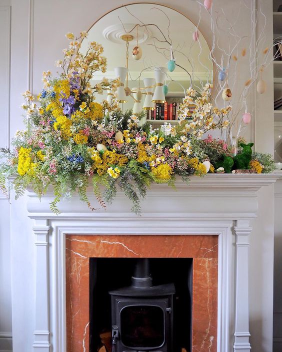 a colorful Easter mantel with a lot of bright blooms and greenery and an Easter tree with pastel eggs is fantastic