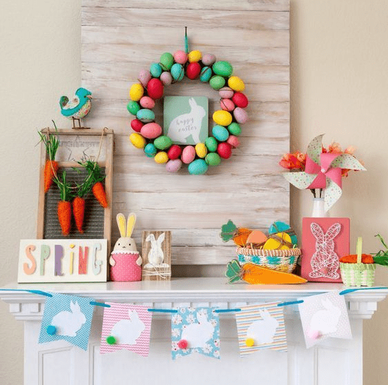 a colorful and fun Easter mantel with a bright egg wreath, a bunny bunting, a string art piece, some bunnies and a carrot garland