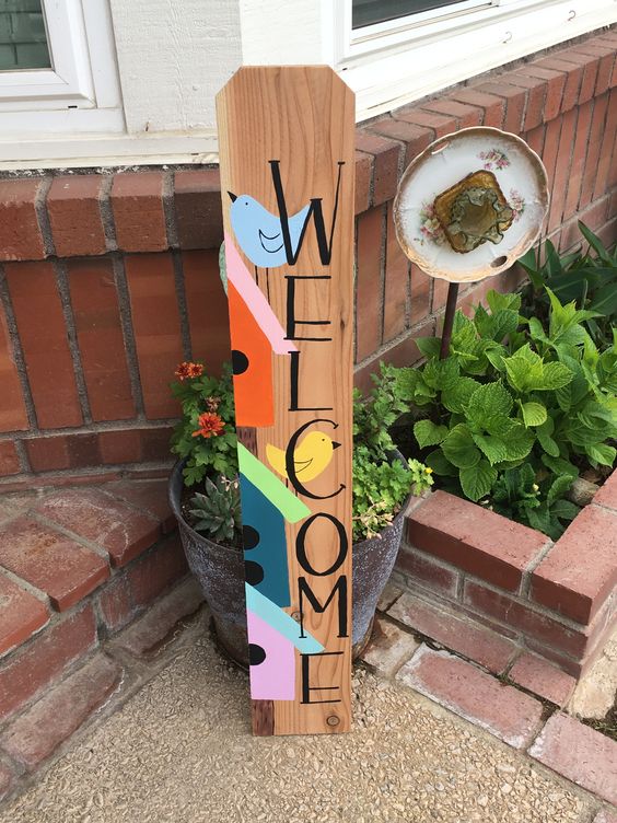 a colorful spring sign showing various bird houses and a bird is a lovely idea for a spring porch
