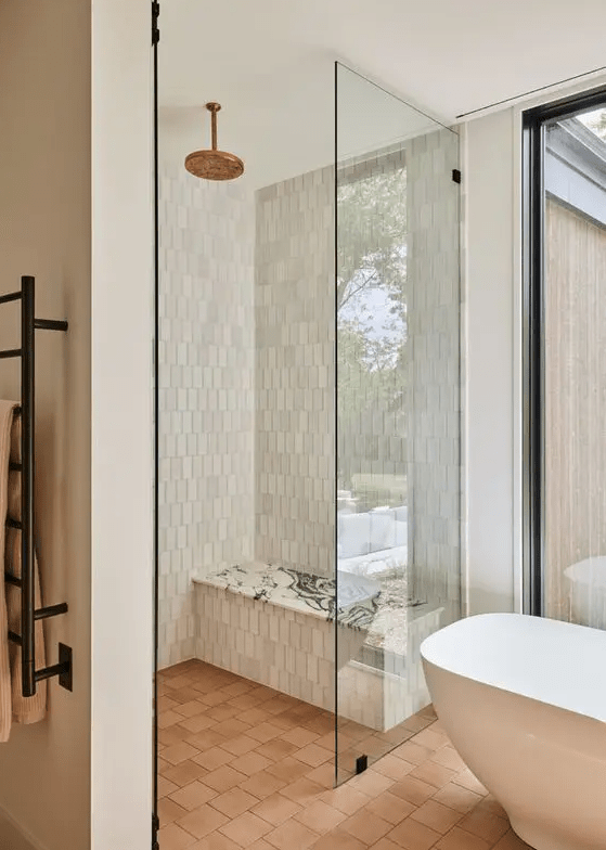 a contemporary bathroom with a glazed wall for a view, a shower space, a tub, clad with Zellige and terracotta tile