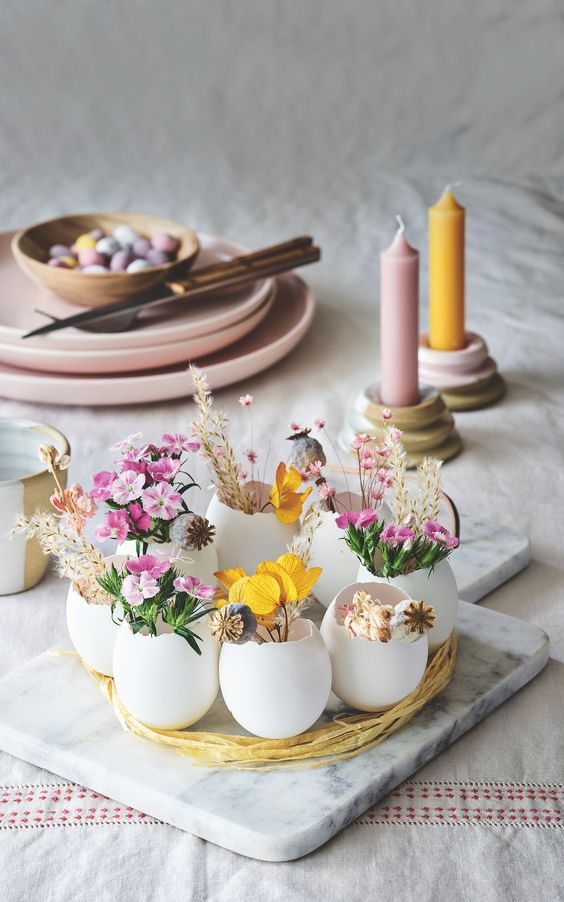 a cool Easter centerpiece of egg shells with bright blooms and dried grasses is a cool idea for any modern party