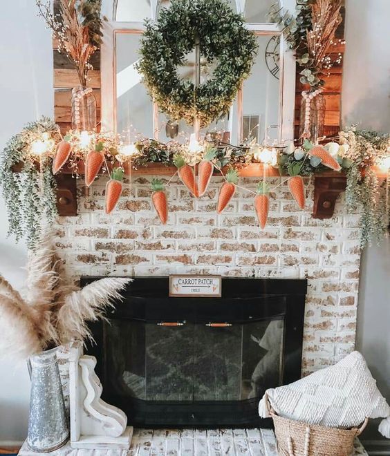 a cool rustic Easter mantel with a faux greenery garland, a carrot garland, lights, a greenery wreath and beads