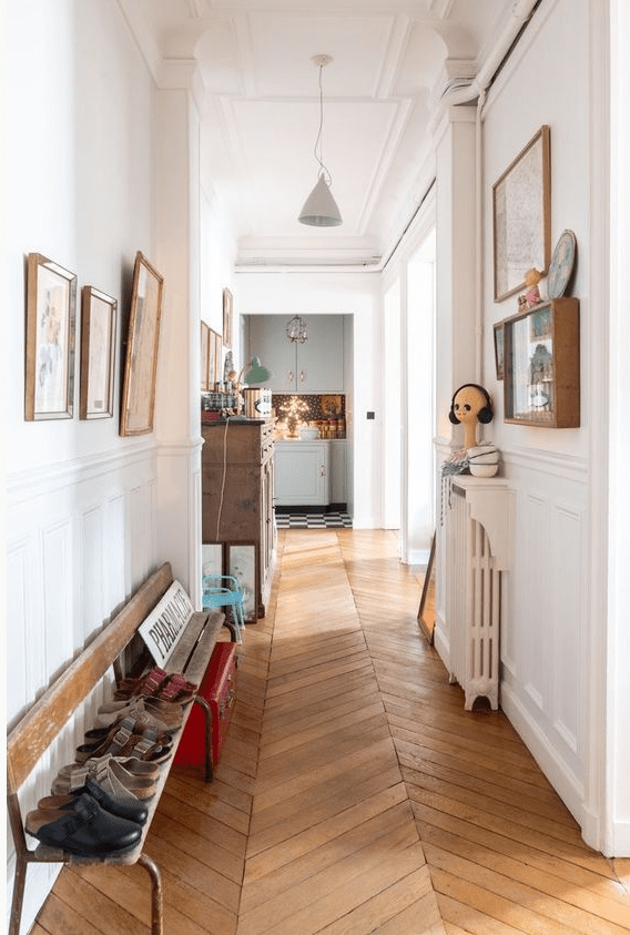 a corridor with molding, chevron floors, a shabby chic bench, some art and decor for an ecletic look