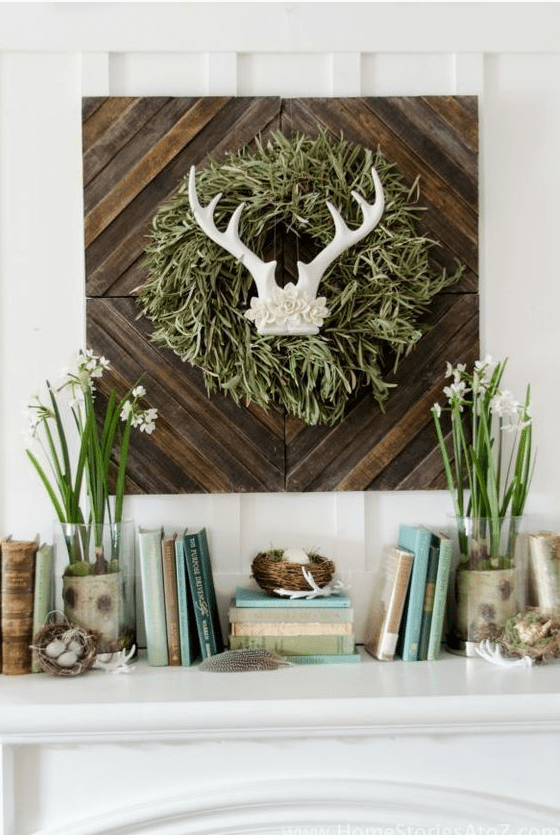 a cute spring mantel with a touch of wild, blooming bulbs, nests with fake eggs and a sign with antlers and a grass wreath