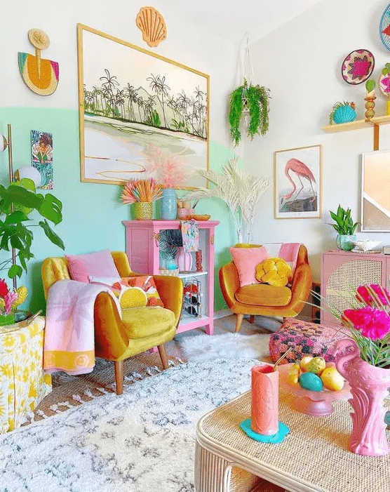 a dopamine decor living room with a bold aqua accent wall, marigold chairs, colorful texiles, greenery and bright decor