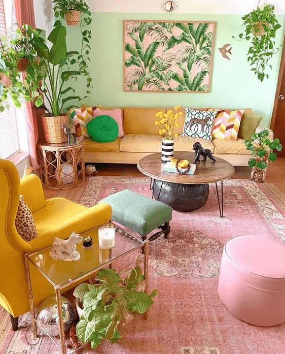 a dopamine decor living room with a light green accent wall, a yellow sofa, a bold yellow chair, a pink rug and pouf plus a green stool