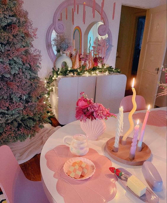 a dopamine dining room with a creative tree decorated with pink baby's breath, a sideboard with bright decor, pink candles and a quirky pink place setting