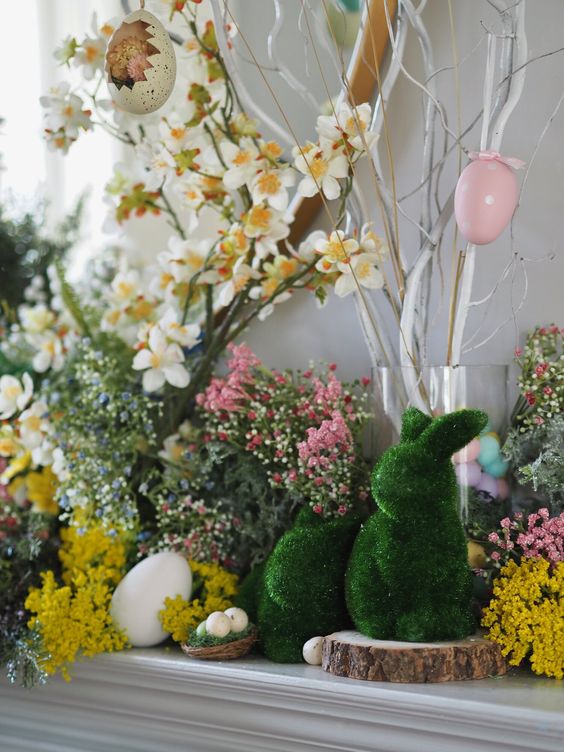 a fresh Easter mantel with moss bunnies, fake eggs, bright blooms and an Easter tree with eggs