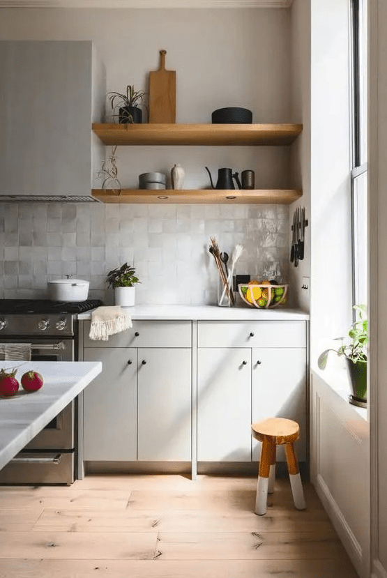 a grey Scandinavian kitchen with open shelves, white countertops, a neutral Zellige tile backsplash and potted plants