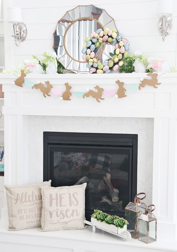 a lovely pastel Easter mantel with a bunny banner, a pastel egg wreath and faux blooms and greenery is cool
