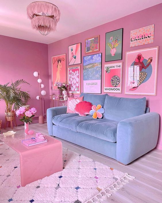 a mauve dopamine decor living room with a blue sofa, a pink table, a colorful gallery wall and a pink chandelier