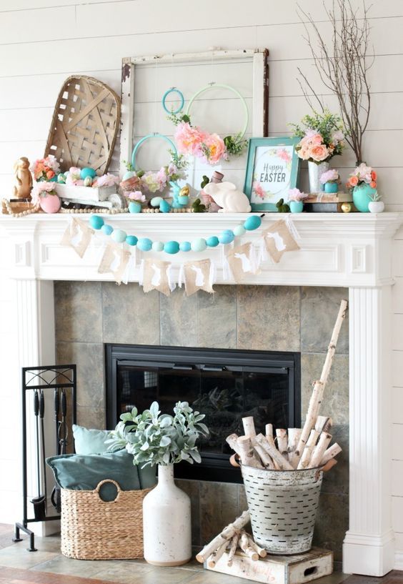 a messy rustic Easter mantel with a turquoise egg garland, a banner, some faux blooms, bunnies, branches and a basket is fresh and bold