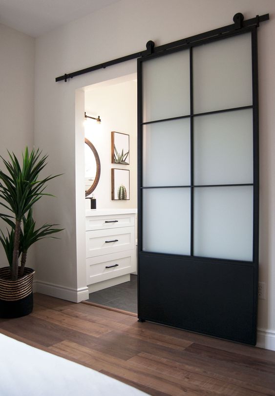 a modern black barn door features glass panes is a cool idea if you want the door to look more lightweight and airy