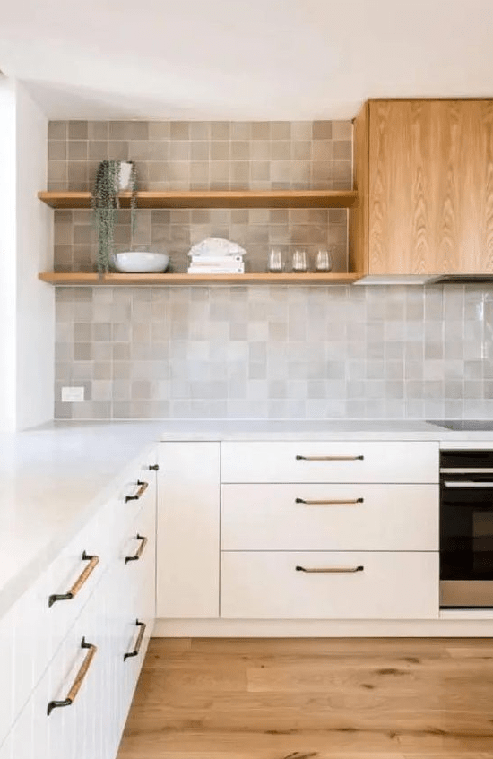 a neutral modern kitchen with fluted cabinets, a zellige tile backsplash, open shelves and a wood clad hood