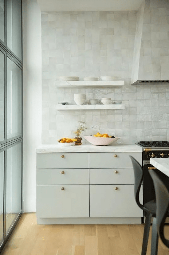a plain dove grey kitchen with gorgeous mother of pearl zellige tiles covering the whole wall and the hood for more interest
